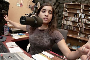 Animal sciences junior Yael Farah aka DJ Rooftop, sets up music during her show The Harmonic Cacophony yesterday at the KAMP Student Radio studio. KAMP has found itself in financial distress and is asking students to approve a $1 fee that will help keep it operating. 
