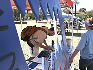 John Keogh, a biochemistry senior, signs the Arizona Public Interest Research Group petition to keep credit card solicitors away from college campuses.