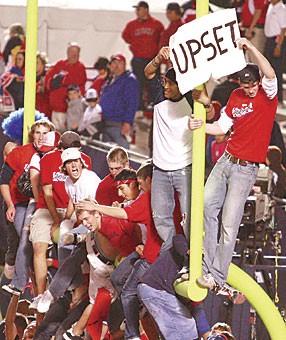 Fans climb onto the goalposts after the Wildcats 34-24 upset of No. 2 Oregon last night at Arizona Stadium. It was the second time this year and the second game in a row that students have rushed the field.