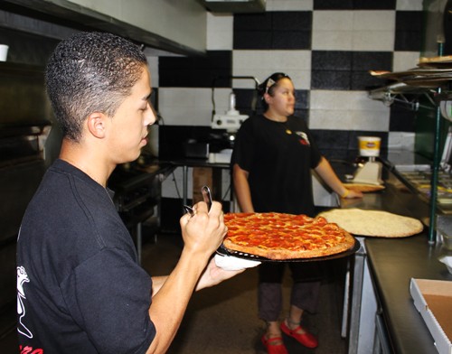 Lisa Beth Earle / Arizona Daily Wildcat

Adrian Chacon, a Pima Community College student and employee at Mario's Pizza, brings a pizza hot out of the oven to a to-go box. Mario's is a local Tucson restaurant that has been serving up pizza and other Italian favorites, including spaghetti and lasagna, for over 28 years.