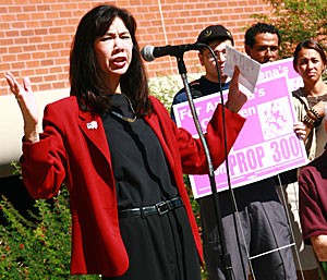 Lorraine Lee, director of Chicanos Por La Causa, speaks against Proposition 300 to a crowd of nearly 40 at the James E. Rogers Plaza yesterday afternoon. If passed, Prop. 300 will require illegal immigrants to pay out-of-state tuition, deny them adult education and deny the children of undocumented immigrants citizenship rights such as child care.  