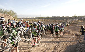 Thousands of riders get off their bikes and hike across the Santa Cruz River on Saturday morning during the El Tour De Tucson. The 25th incarnation of this annual event was the largest yet, drawing more than 10,000 cyclists from across the nation.