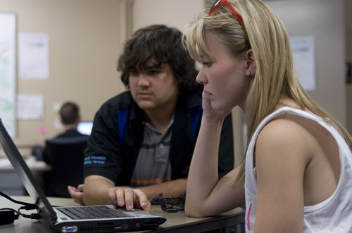 Tim Glass / Arizona Daily Wildcat

Katie Rubel, a history senior, watches as Andre Takagi, an OSCAR staff member and junior at Pima Community College installs software on her computer.  The 24/7 OSCAR center located at Martin Luther King Jr. building has about 50 walk-in clients per day.