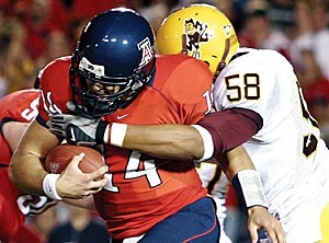 UA quarterback Adam Austin tries to scramble away from the rush of ASU defensive end Dexter Davis in the Wildcats 28-14 loss to the Sun Devils Saturday at Arizona Stadium. After entering the game for injured starting quarterback Willie Tuitama, Austin threw two interceptions and led an ineffective Arizona offense that failed to even drive into ASU territory in the second half.