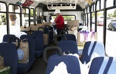 Deborah Kimball, part of the Staff Advisory Council, fills a CatTran bus with donated food items yesterday as part of the Stuff-the-CatTran food donation drive.
