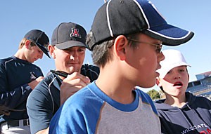 Sophomore lefthander Matt Denker signs autographs for fourth-graders from Wilson K-8 yesterday at Sancet Stadium. The Arizona baseball team read to and signed autographs for the Tucson students.