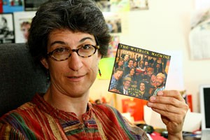 Beverly Seckinger, associate professor and interim director of the School of Media Arts, holds an album of the band she toured with in 2006, The Wayback Machine. It was on tour when she began creating a film focusing on hippies.