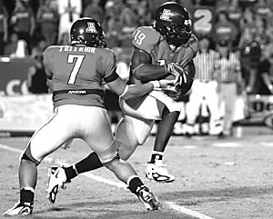 Sophomore quarterback Willie Tuitama hands off to junior running back Chris Henry in the second half of Arizonas 16-13 win over Brigham Young Saturday at Arizona Stadium. Henry carried 13 times for 63 yards, most of which came on a 54-yard scamper in the third quarter. 