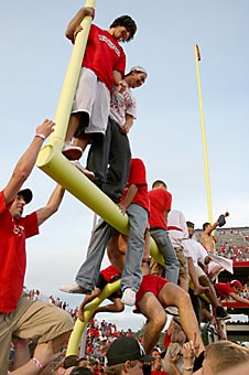 Students climb on the north field goal posts after the Wildcats defeated the University of California at Berkeley Golden Bears on Saturday. Tucson Police Department and University of Arizona Police Department are not going to prosecute students who rushed the field.