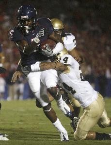 UA runningback Nic Grigsby powers through a tackle by an Idaho defender in a 70-0 Wildcat victory over the Vandals at Arizona Stadium Saturday night. Grigsby had 169 yards on 19 carries and two touchdowns, all in the first half of play.