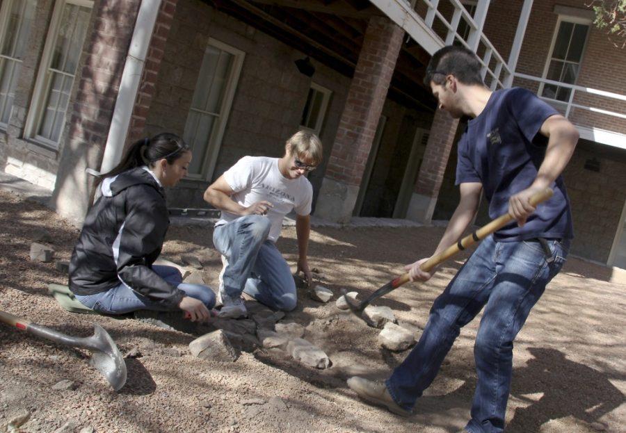 Kevin Brost / Daily Wildcat

Allie Pena, Keith Kolweit and Jacob Prietto help build a trench that dissipates rainwater away from the foundation of Old Main, which began to deterioate after years of water erosion.
