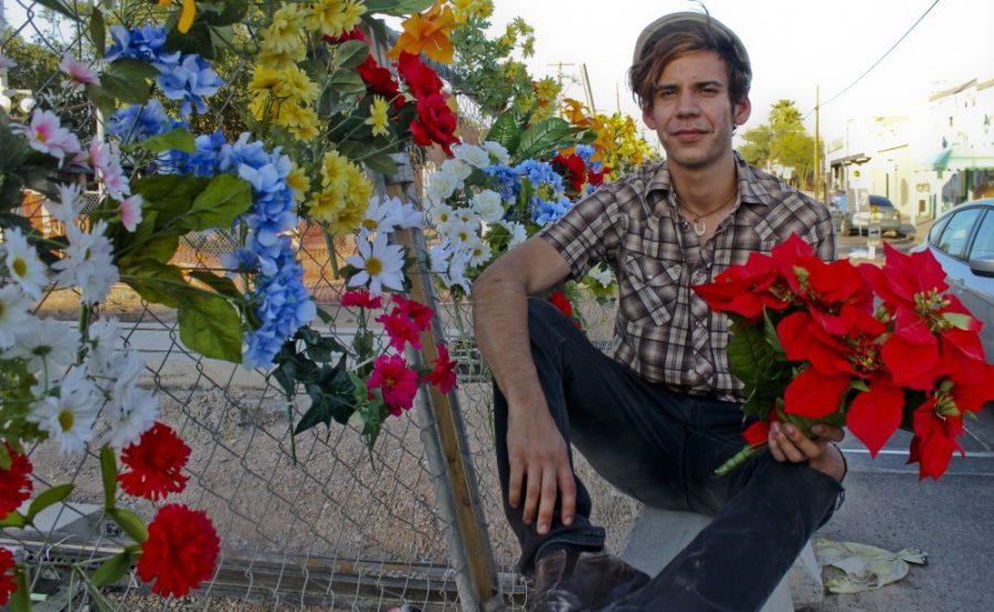 Robert Alcaraz/Arizona Summer Wildcat

Nick Carrillo sits next to the construction site on 4th Ave and 6th St, where he has assembled flowers on various fences as a peaceful protest.