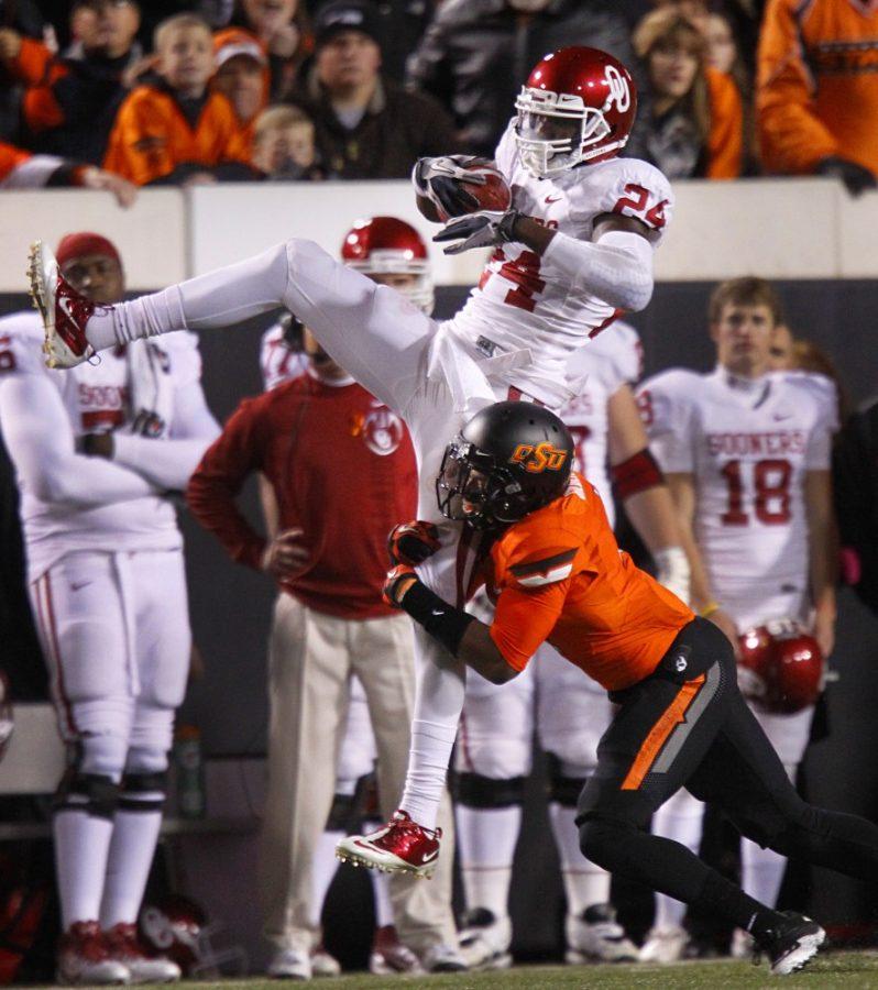 Oklahoma Sooners wide receiver Dejuan Miller (24) goes high for a first-quarter reception as Oklahoma State Cowboys cornerback Justin Gilbert (4) makes the hit at Boone Pickens Stadium in Stillwater, Oklahoma, Saturday, December 2, 2011. (Tom Fox/Dallas Morning News/MCT)