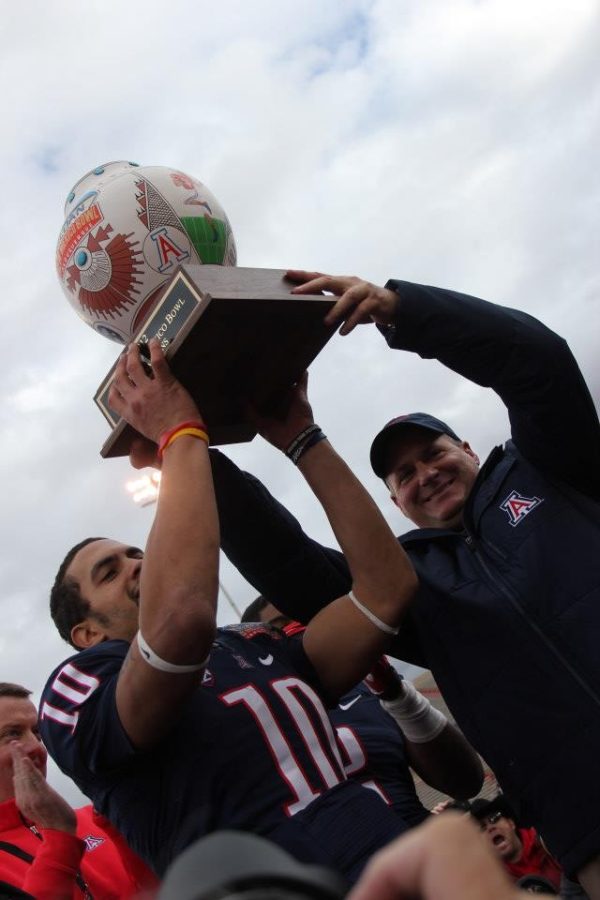 	<p>Quarterback Matt Scott and head coach Rich Rodriguez hoist up the New Mexico Bowl trophy after an improbable 49-48 win against Nevada at University Stadium in Albuquerque. Scott was named the offensive <span class=