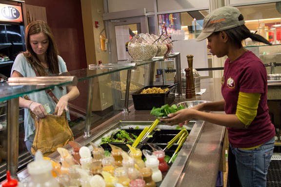 Maddy Linn, 18, left, custom orders a chicken and spinach salad at Core in the UA Student Union, from an employee, Aliah Robinson,19, right, on Thursday, Jan. 10, 2013 in Tucson, Ariz. 