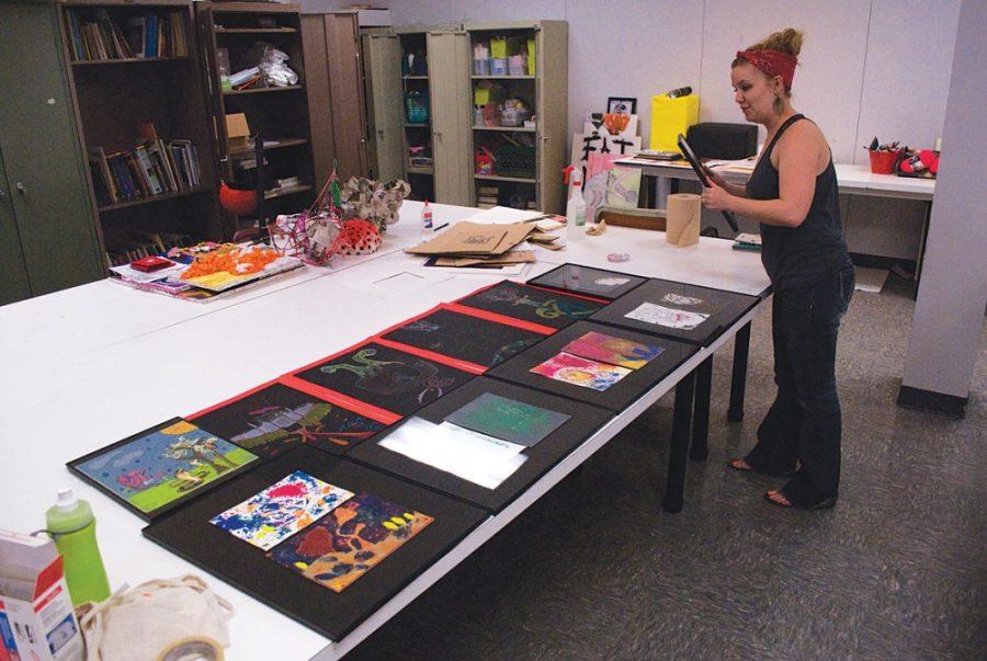 Matthew Fulton / Arizona Daily Wildcat

Caitlin Cardenas, BFA Art & Visual Culture Education major, prepares artwork created by high school students she teaches. The art will be showcased in the Wildcat Art Program exhibition this Saturday in the Union Gallery.
