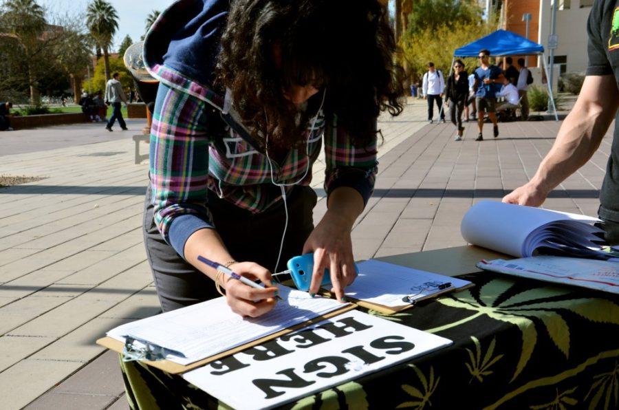 Rebecca Noble / The Daily Wildcat

Rvwaida Alansary, a sophomore physiology major, signs the Students for a Sensible Drug Policys marijuana legalization petition at Heritage Hill on the UA Mall on Tuesday. Alansary signed the petition because she believes that the legalization of marijuana would be fair upon considering the legality of alcohol. 