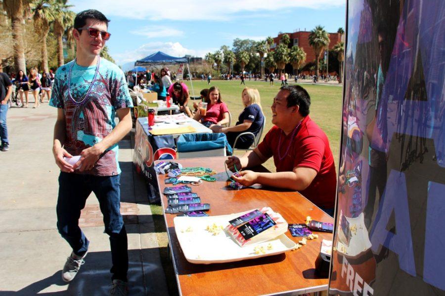 Cecilia Alvarez/ The Daly Wildcat

Jeremy Derois (left), a film and television major, and Ken Peng (right), a non-degree seeking grad student, pass out flyers, popcorn, and beads for the Cat Crawl event on the UA Mall on Wednesday. The Cat Crawl will be at the Student Union Memorial Center on Friday at 10pm..   