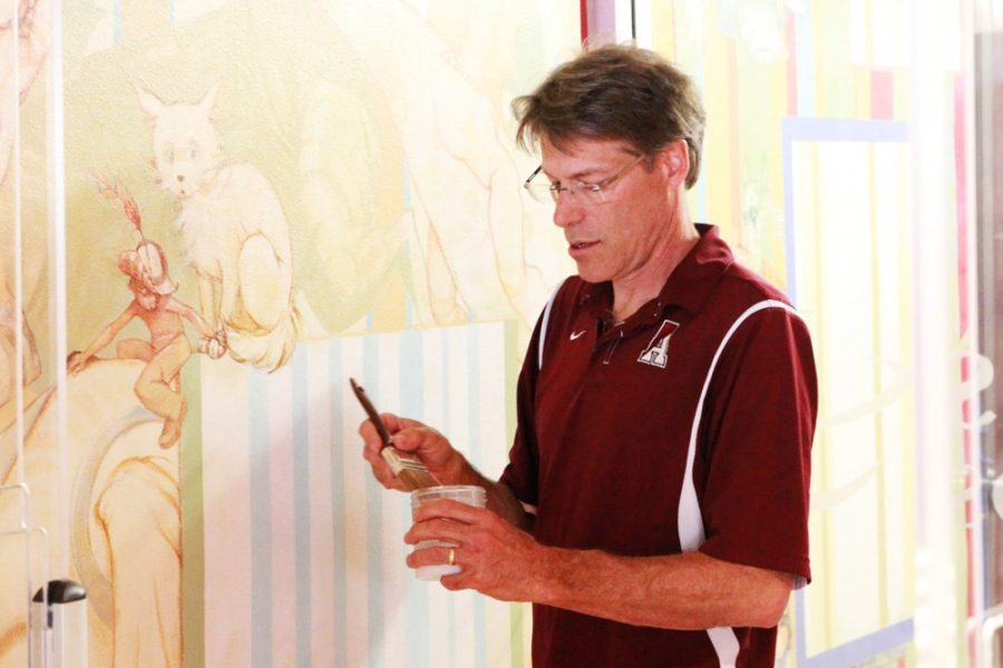 Shane Bekian / The Daily Wildcat

Artist Dave Christiana paints a layer of varnish on his mural at the grand reopening of the College of Education Library on Tuesday. Christiana is a professor of Illustration at the UA School of Art. 