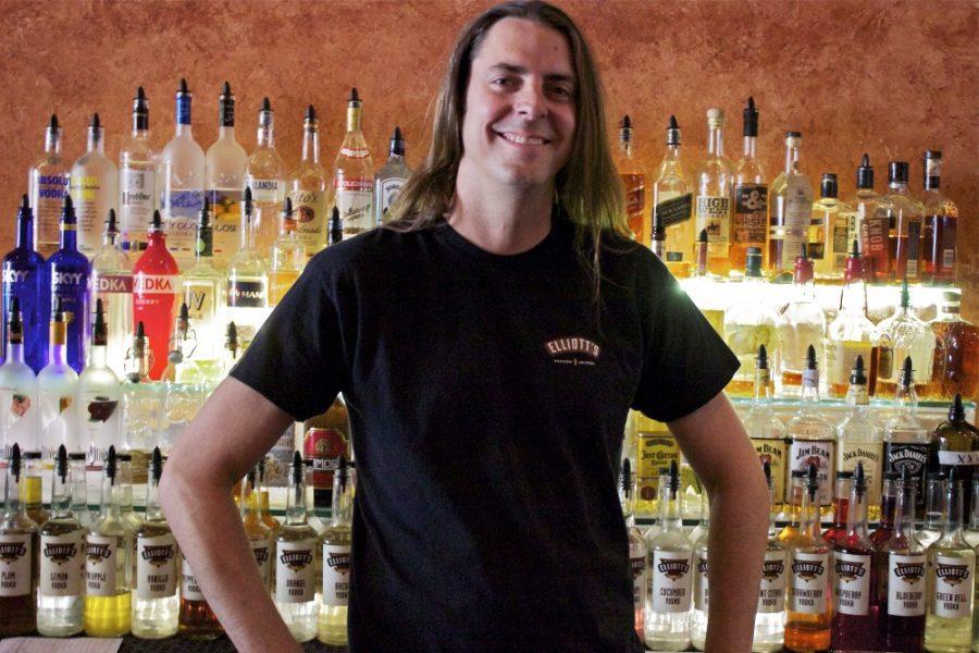 	Gabriel Mallin, a bartender at Elliott’s on Congress, stands before the bar’s impressive display of house-infused vodkas and other liquors on Thursday.