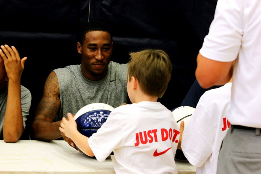 	Sophomore forward Rondae Hollis-Jefferson signs a basketball for a child attending the Sean Miller Basketball Camp. Renovations to McKale Center forced the Sean Miller Basketball Camp to be held in the Richard Jefferson Gym. 