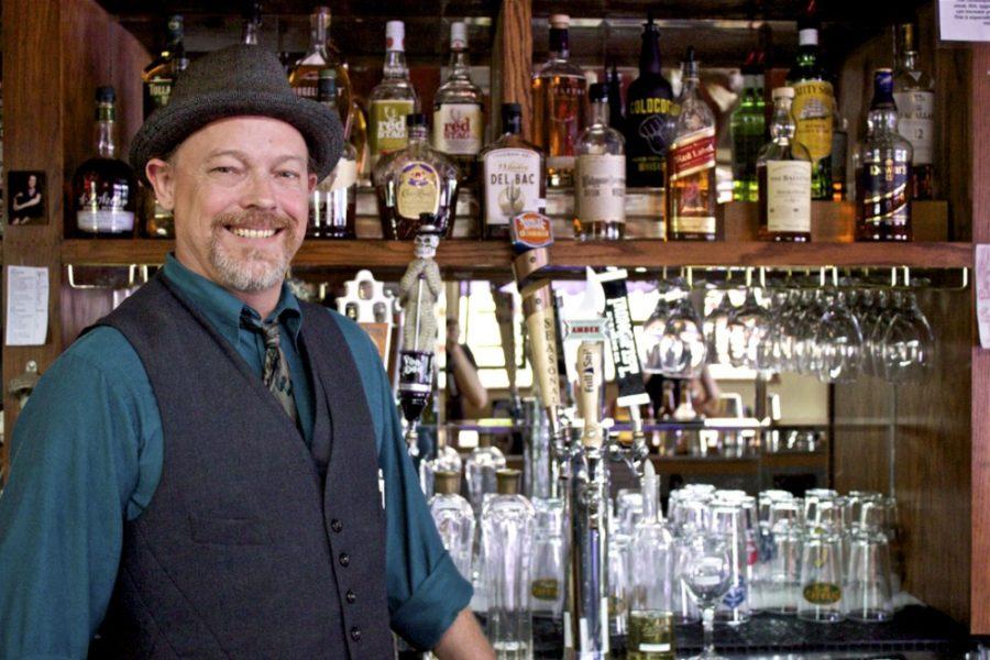 	Chris Baldwin, manager of Delectables Restaurant & Catering, poses in front of the bar’s expansive selection of spirits.