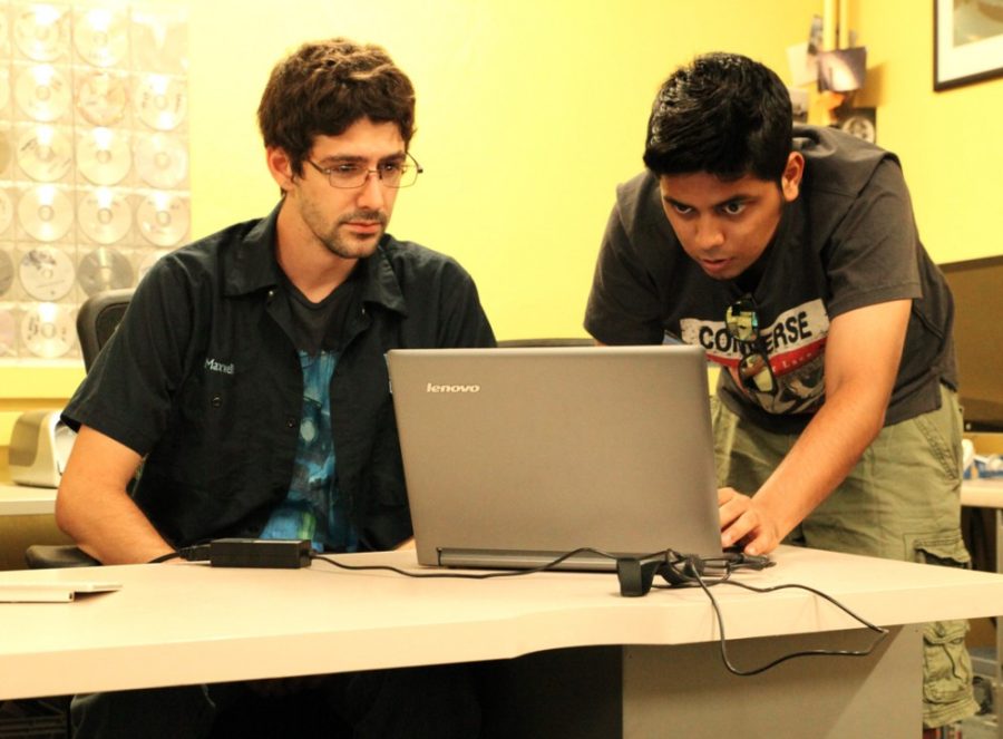 Kyle Hansen / The Daily Wildcat

MCB senior Maxwell White (left) assists Engineering Management graduate Dhuva Kapoor (right) at the UTIS building on Monday, Sept. 15 2014. UTIS is currently under new management and serving a larger customer base. 