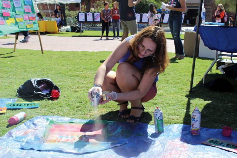 Kyle Hansen / The Daily Wildcat

Ph.d candidate in Language, Reading, and Culture Mariia Khorosheva spray paints a t-shirt at the LGBTQ Coming Out Week Resource Fair on the UA mall on Monday, Oct. 13. Coming Out Week gives students support to come out to their parents and friends.