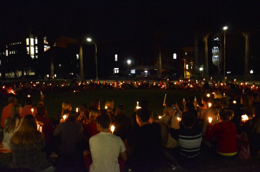 Friends of Jake Cilek raise candles in a moment of rememberance during an emotional candlelight memorial on the UA Mall on Monday. Around 200 people gathered on the UA Mall to share their memories of Cilek.
