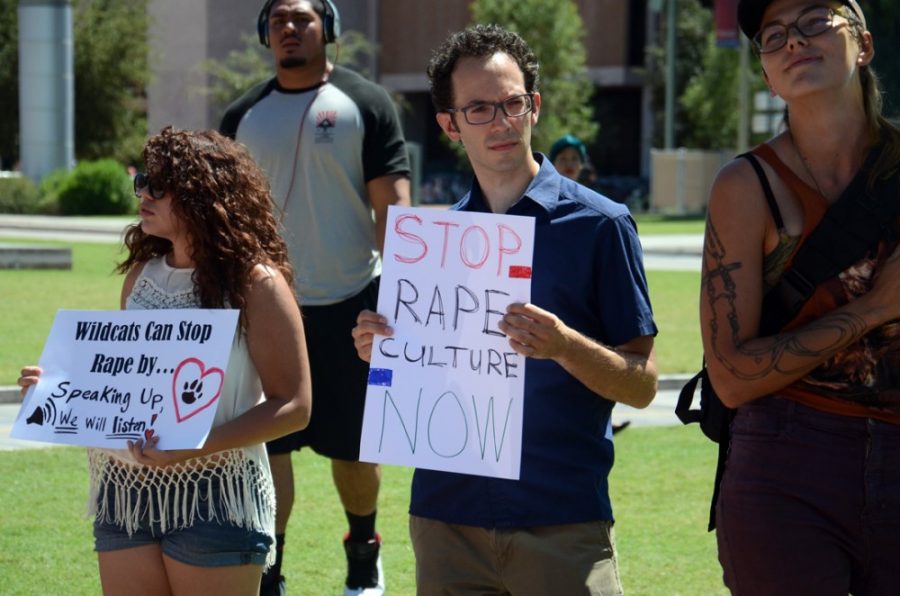 Rebecca+Noble+%2F+The+Daily+Wildcat%0A%0ALinguistics+freshman+Brenda+Stoiber-Boudin+%28left%29%2C+4th+year+PhD+candidate+Matt+Matera+%28right%29+protest+against+rape+culture+and+a+recent+column+published+by+the+Daily+Wildcat+on+the+UA+mall+on+Thursday%2C+Sept.+11.