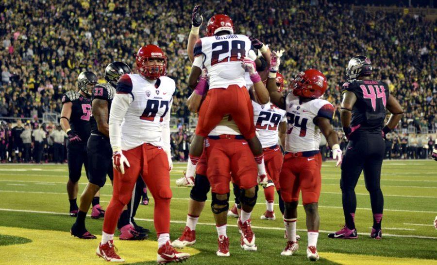 The Arizona Wildcats celebrate Arizona freshman running back Nick Wilsons (28) touchdown during Arizonas 31-24 win against Oregon at Autzen Stadium in Eugene, Ore., on Thursday. In the first season of the college playoff system, football head coach Rich Rodriguez has a chance to make the Final Four before UA mens basketball head coach Sean Miller.