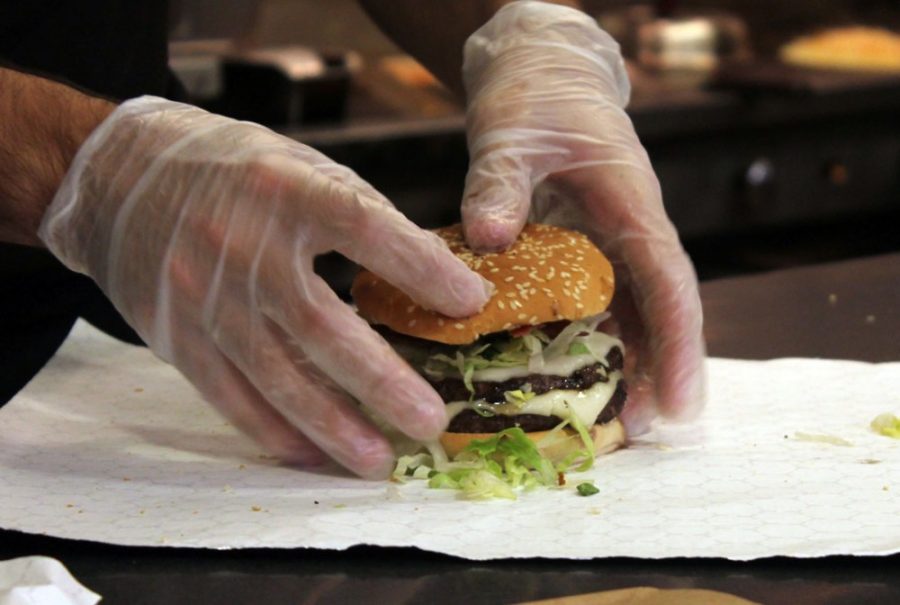Zac Lusk, a Route 66 Grill employee and education sophomore, prepares a hamburger at Park Student Union on Monday.