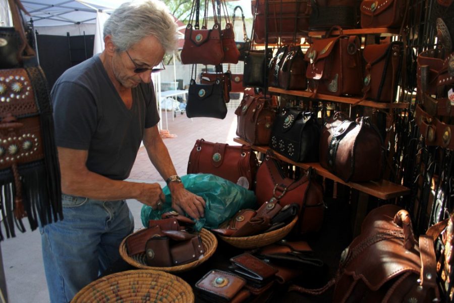 Rebecca Marie Sasnett  / The Daily Wildcat

Joel Rubiner, artist, sets up his leather bags and belts booth outside of the Tucson Museum of Art on Thursday, Nov. 20, 2014, in preparation for the Holiday Artisans Market at the Tucson Museum of Art. Rubiner started in Tucson in 1965. 
