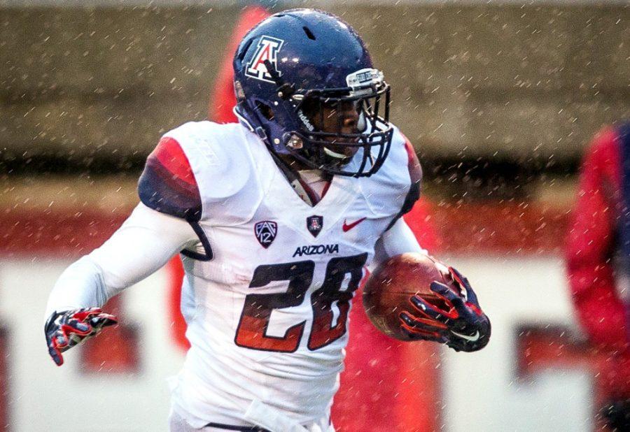 Courtesy of Conor Barry / Daily Utah ChronicalDespite the rain and cold weather, Arizona running back Nick Wilson (28) runs for a touchdown during Arizonas 42-10 win against Utah at Rice-Eccles Stadium on Saturday. Wilson and the Wildcats fought through the weather to keep their Pac-12 Conference title game hopes alive.