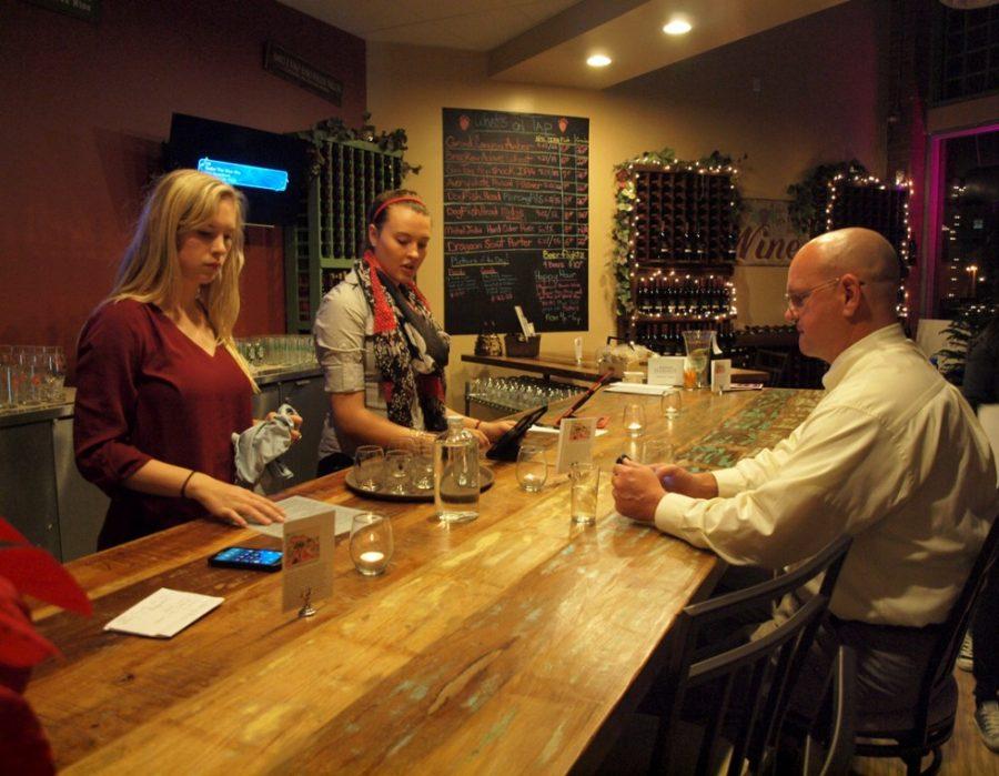 Brittan Bates / The Daily Wildcat

 Psychology major, Sarah Stricker and agricultural education major, Maya Schaw, serve Chris Walker at Bear Track U Winery on University Blvd. on Thursday, Jan. 29, 2015. The winery is new to University this year.