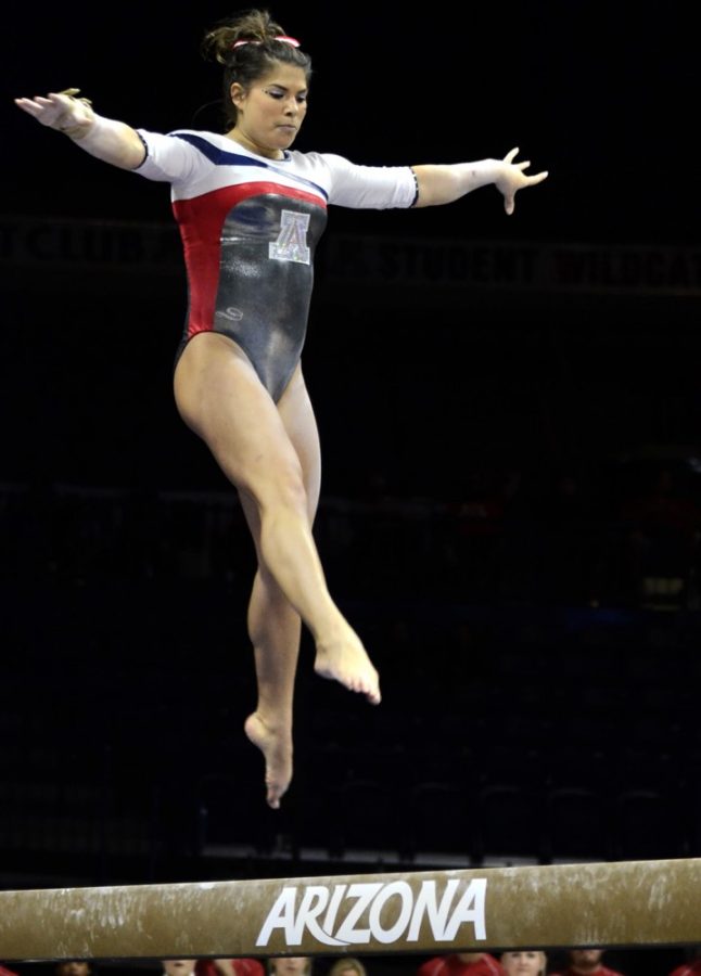 <p>Arizona gymnast Allison Flores performs on the beam during Arizona's 196.625-195.375 win against ASU in McKale Center on Monday. Flores finished first in the all-around competition with a score of 39.350.</p>