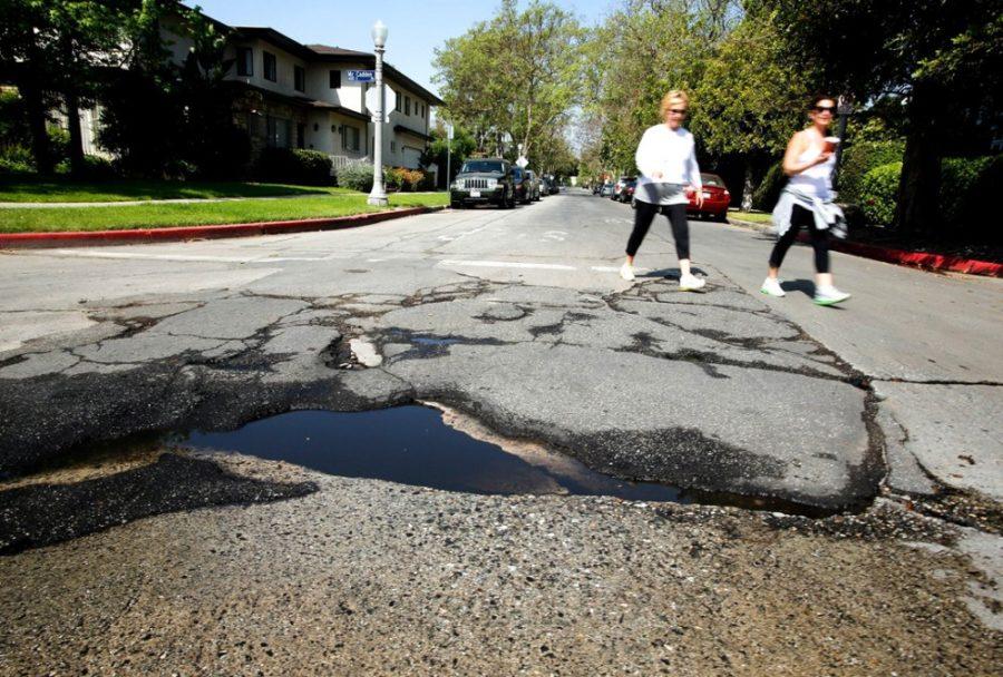 Pedestrians+walk+near+a+pothole+in+need+of+repair+at+the+intersection+of+McCadden+Pl.+and+4th+St.+in+Hancock+Park%2C+Calif.+on+April+22%2C+2013.+%28Mel+Melcon%2FLos+Angeles+Times%2FMCT%29