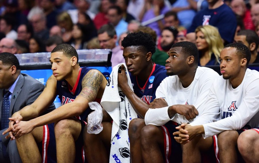 Arizona forward Stanley Johnson (5) tends to his eye after taking a punch while Arizona forward Brandon Ashley (21), left, and guards Kadeem Allen, center right, and Parker Jackson-Cartwright (0), far right, dejectedly look on from the bench during Arizonas 85-78 loss to Wisconsin in the Elite Eight of the NCAA Tournament in the Staples Center in Los Angeles, Calif. on Saturday night.