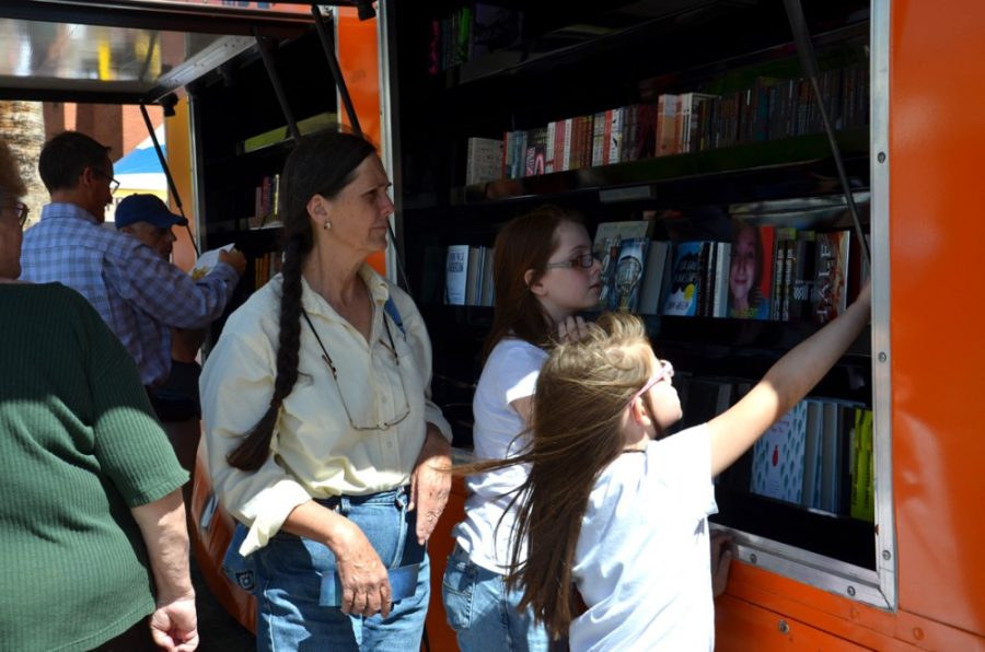 Rebecca Noble/ The Daily Wildcat

Kathy Padilla and her granddaughters, Victoria and Isabella Padilla, browse the Penguin Book Trucks selection at the Festival of Books on the UA Mall on Saturday, March 15th.  Penguin Books sends their hot dog cart inspired book trucks around the country to a variety of book related events.