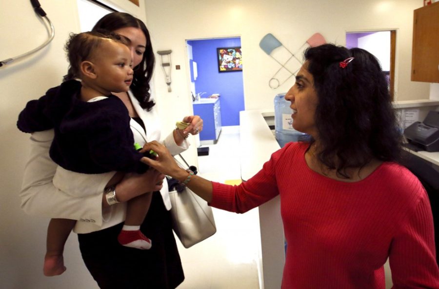 Dr. Monica Asnani, right, says goodbye to Kristian Richard, 1, being held by his mother Natasha, after the baby was given an MMR vaccine at the Medical Arts Pediatric Med Group in Los Angeles on Feb. 6, 2015. (Mel Melcon/Los Angeles Times/TNS)