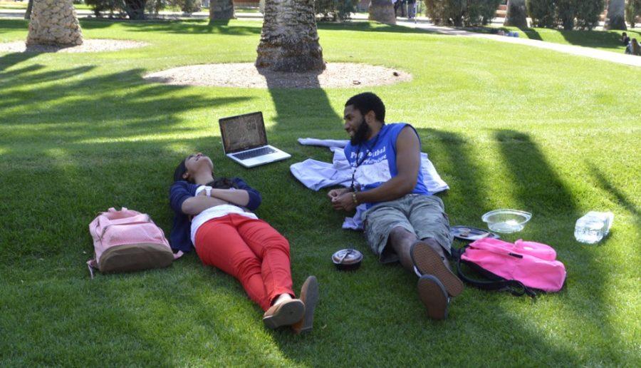 Physiology freshman Aishwarya Karlapudi (left) and business and  management freshman Winkfield Twyman (right) spend their afternoon  sitting on the grass outside the Arizona State Museum on Monday.  Catching up on some rest and relaxation on the UA campus is one of the  things students can enjoy about spring.
