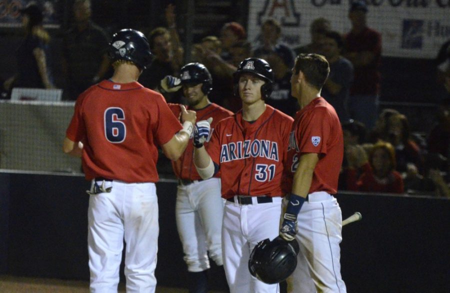 Arizona baseball catcher Riley Moore (6) celebrates with teammates Kevin Newman (2) and Michael Hoard (31) during Arizonas 17-6 victory over ASU at Hi Corbett Field. The Wildcats won their Washington State series to move up one spot in the Pac-12 Conference power rankings.