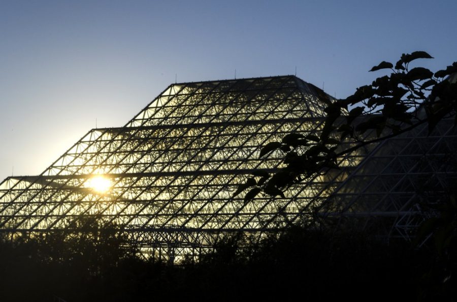 The setting sun shines through the Biosphere 2.  The structure, resembling a greenhouse, once supported a materially-isolated system of life, including an ocean, rainforest, savanna, and more.