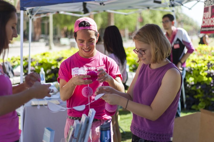 Alex Ross, vice president of VOX: Voices for Planned Parenthood works with other members on decorations at Pink Out on the UA Mall on Tuesday, Sept. 29. Pink Out was a nationwide event to stand in solidarity with Planned Parenthood.