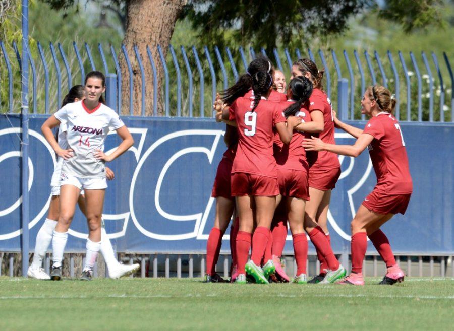 Stanford celebrates while Arizona midfielder Jaden DeGracie (14) stares in disbelief following Stanfords winning goal in the second overtime period on Sunday, Oct. 4, 2015 on Murphy Field at Mulcahy Soccer Stadium. The Wildcats lost for the third year in a row in overtime against the Cardinal.