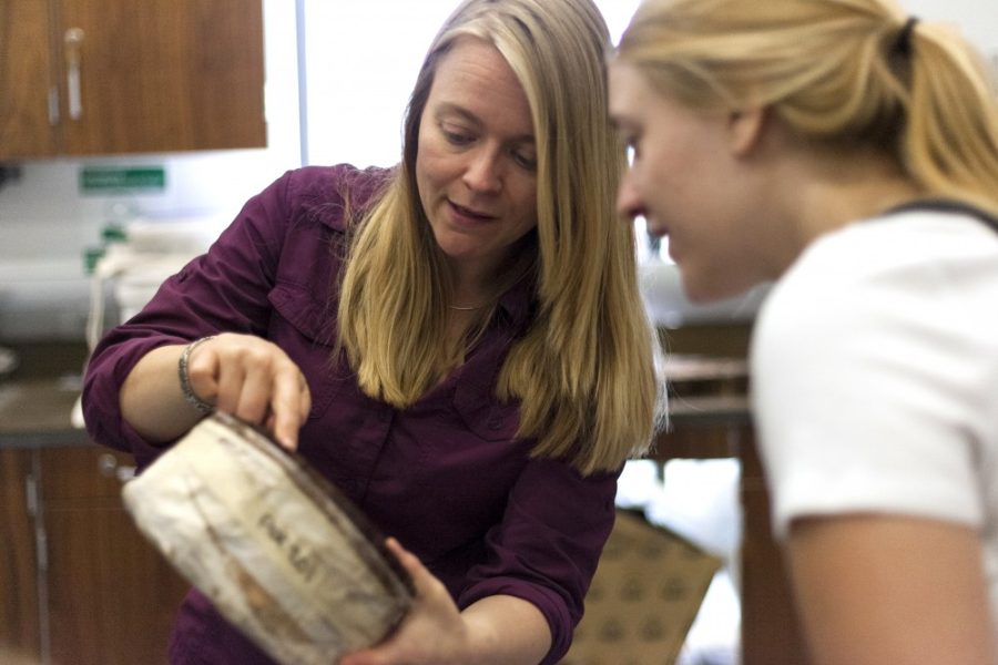<p>Assistant Research Professor Charlotte Pearson (right) and Piper-Lenore Murphy (left) examine a tree ring sample.</p>