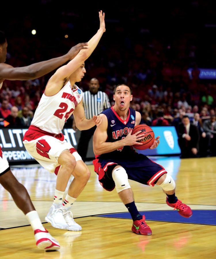 Then-Arizona point guard TJ McConnell (4) ducks to avoid the Wisconsin defense in McKale Center on Saturday, March 28, 2015. The Philadelphia 76ers point guard recently hit the game-winning shot against the Brooklyn Nets and has produced in the NBA preseason thus far. 
