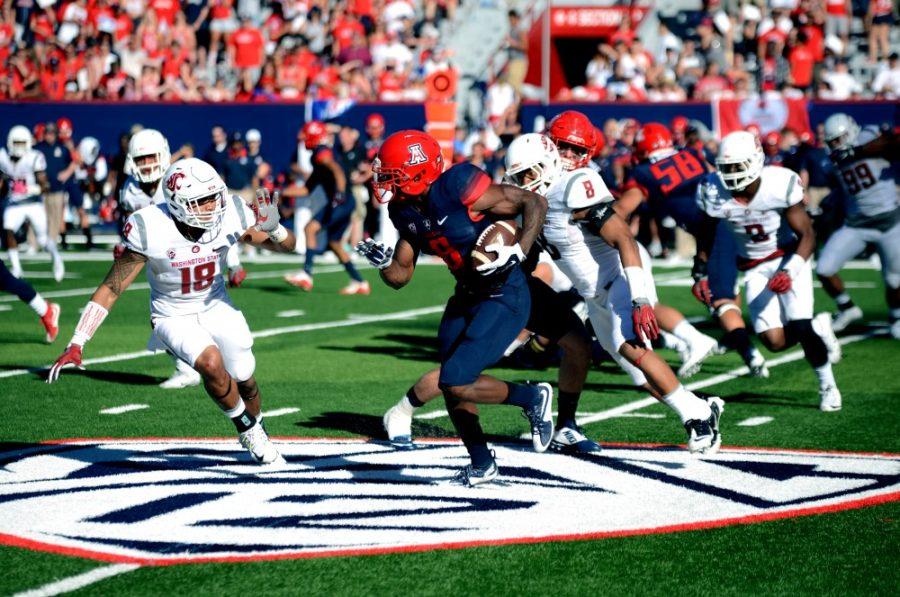 <p>Quarterback Jerrard Randall (8) sneaks the ball past Washington State's defensive line on Saturday, Oct. 24. Randall threw for 137 yards and two touchdowns and added 105 yards on the ground in the Wildcats' 45-42 loss.</p>