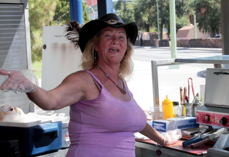 Perdida Joy, an employee of Nathans Famous hot dog stand located outside of the Harvill building, greets customers with a smile Wednesday afternoon. Joy is known for exceptional hot dogs, fun hats and great customer service.