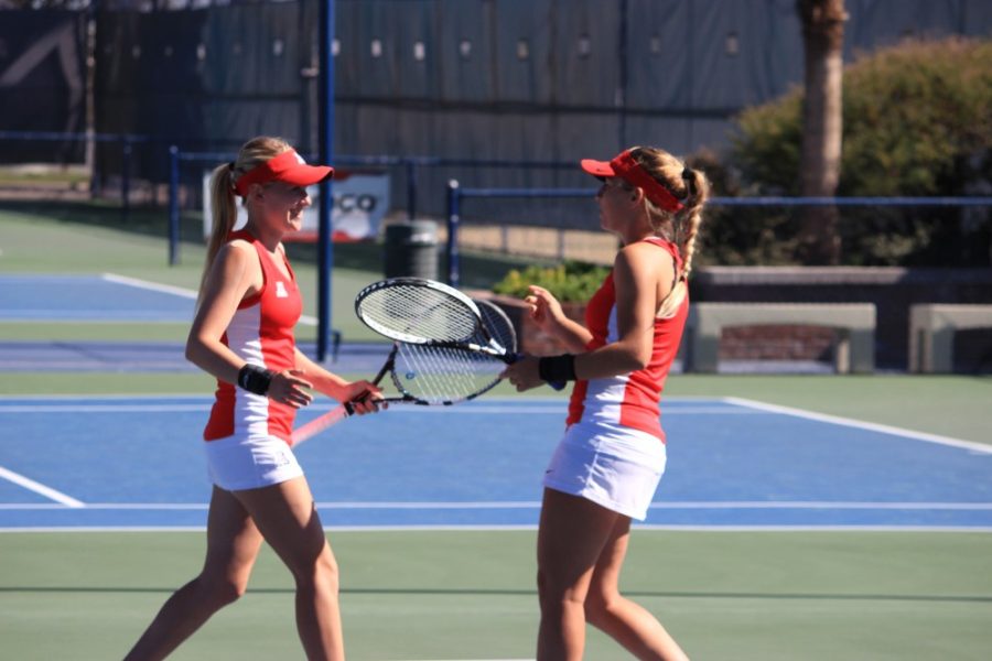 Arizona womens tennis athletes junior Lauren Marker and senior Shayne Austin exchange words of luck before a match against San Diego in Tucson on Friday, Feb. 12. Austin, Marker and Samantha Czarniak make up a trio that has dominated opponents this spring season.
